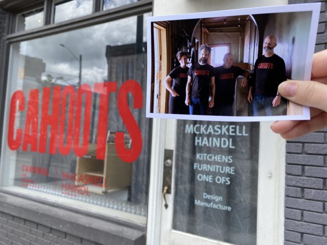 A printed photo of the Mckaskell-Haindl team held up in front of their sign