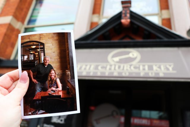 A printed photo of the owners Vanessa and her husband in front of the Church Key Bistro