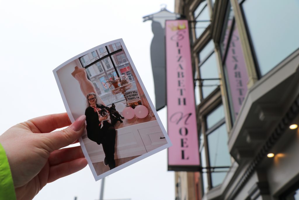 A printed photo of owner Veronica Hosszu is held in front of her store Elizabeth Noel.